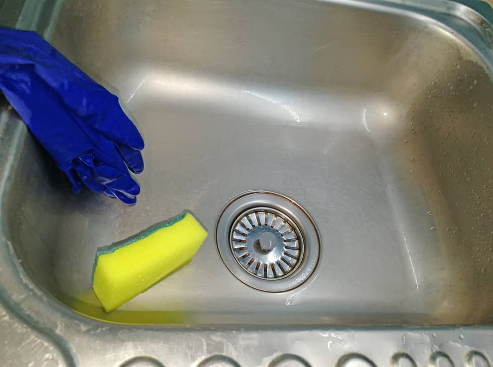 Cleaning the sink that has brown stains.