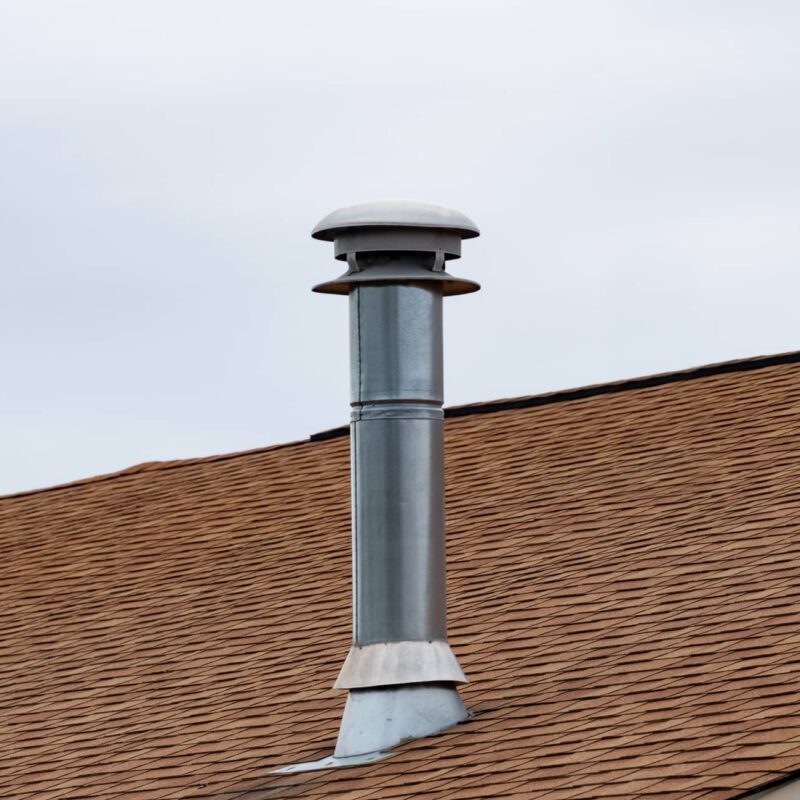 A roof vent pipe that is covered to keep debris out.